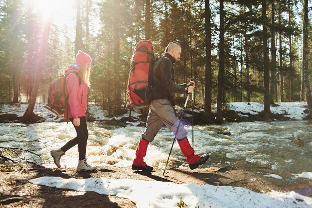 Een groep toeristen bestaande uit jongens en meisjes die in de bossen langs de rivier gaan