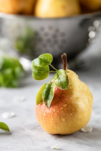 Een groep van peren en stukjes peer op een witte snijplank op een concrete achtergrond