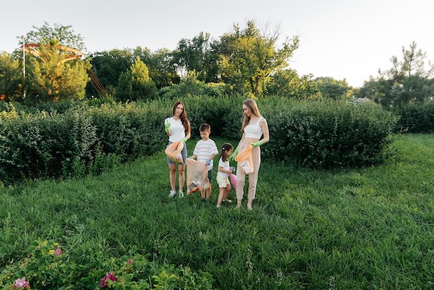 Een groep volwassenen en kinderen samen bij zonsondergang houdt zich bezig met afvalinzameling in het park Milieuzorg afvalrecycling Afval sorteren