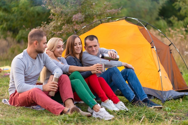 Een groep vrienden geniet van een warm drankje uit een thermoskan