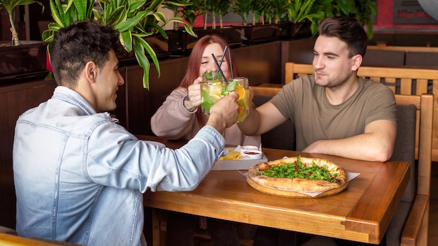 Een groep vrienden rusten in een pub. Eten, drinken, eten op tafel. Vriendschap