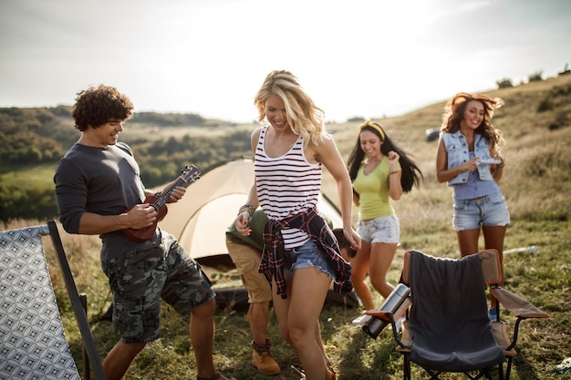 Een groep vrolijke vrienden die plezier hebben buiten hun tent op een festival.