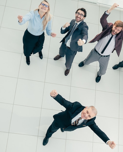 een groep vrolijke zakenmensen die naar de camera kijken