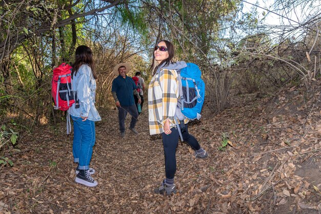 Een groep wandelaars, mannen en vrouwen van verschillende leeftijden, lopen langs een pad in het midden van de natuur en maken een concept van ecotoerisme.