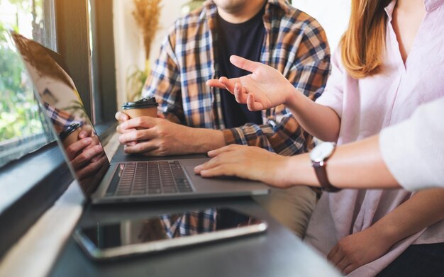 Een groep zakenmensen die een laptop gebruiken terwijl ze samenwerken