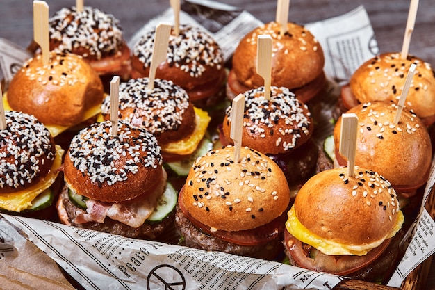 Een groot aantal hamburgers, cheeseburgers die op tafel lagen. seth fastfood. voedselmuur, exemplaarruimte.