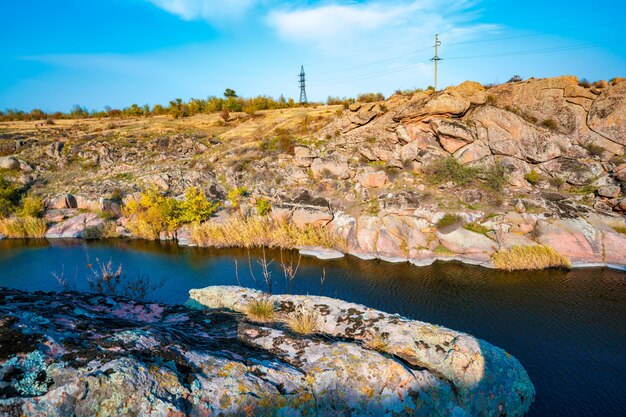 Een groot aantal steenmineralen bedekt met groene vegetatie boven een kleine rivier in het pittoreske Oekraïne en zijn prachtige natuur