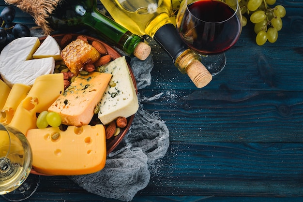 Een groot assortiment kazen, wijn, honing, noten en kruiden op een blauwe houten tafel Bovenaanzicht Vrije ruimte voor tekst