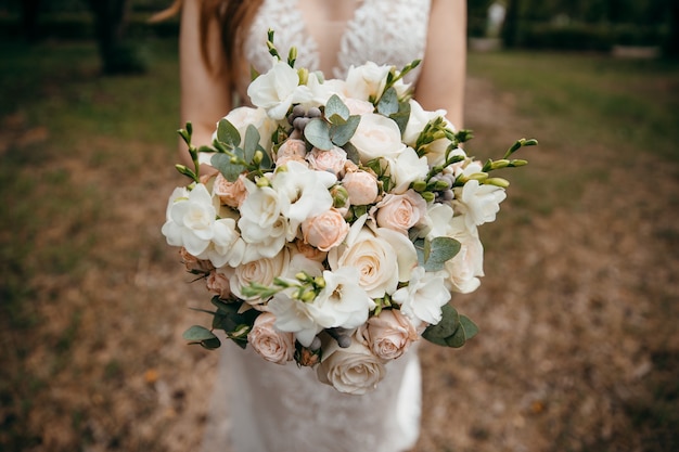 een groot boeket witte rozen in handen