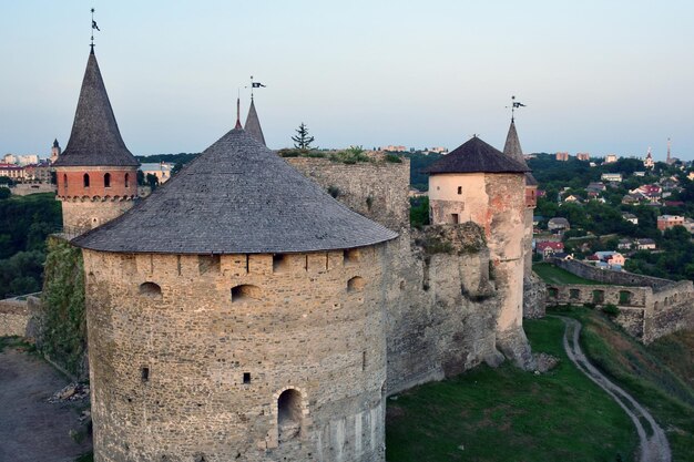 Een groot stenen fort op een heuvel met verschillende torens op de achtergrond van de stad Hoge hoekmening