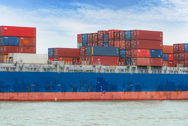 Foto een groot vrachtschip met een groot aantal containers dat midden op zee drijft