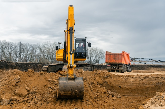 Een grote bouw graafmachine van gele kleur op de bouwplaats in een steengroeve voor steengroeven. Industrieel beeld