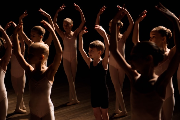 Een grote groep kinderen repeteert en danst het ballet