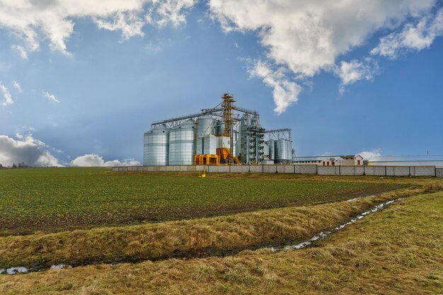 Een grote moderne fabriek voor de opslag en verwerking van graangewassen uitzicht op de graanschuur op een zonnige dag tegen de blauwe hemel Eind van het oogstseizoen