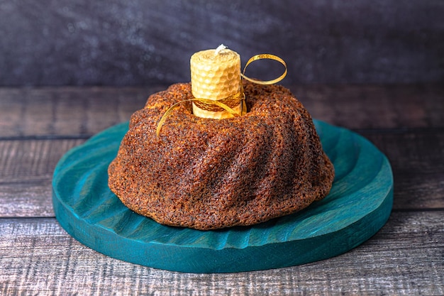 Een grote ronde cupcake op donkere achtergrond met gele kaarsx9xA