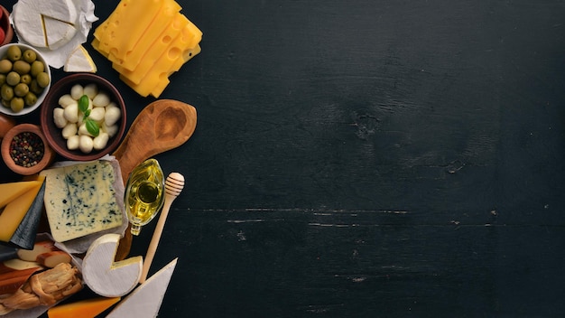 Een grote set kazen Mozzarella blauwe kaas brie kaas maasdam Bovenaanzicht Op een zwarte houten ondergrond Vrije ruimte voor uw tekst