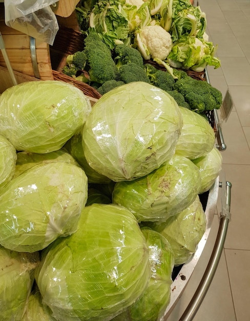 Een grote stapel verse witte kool op de toonbank in een groentesupermarkt of op de markt