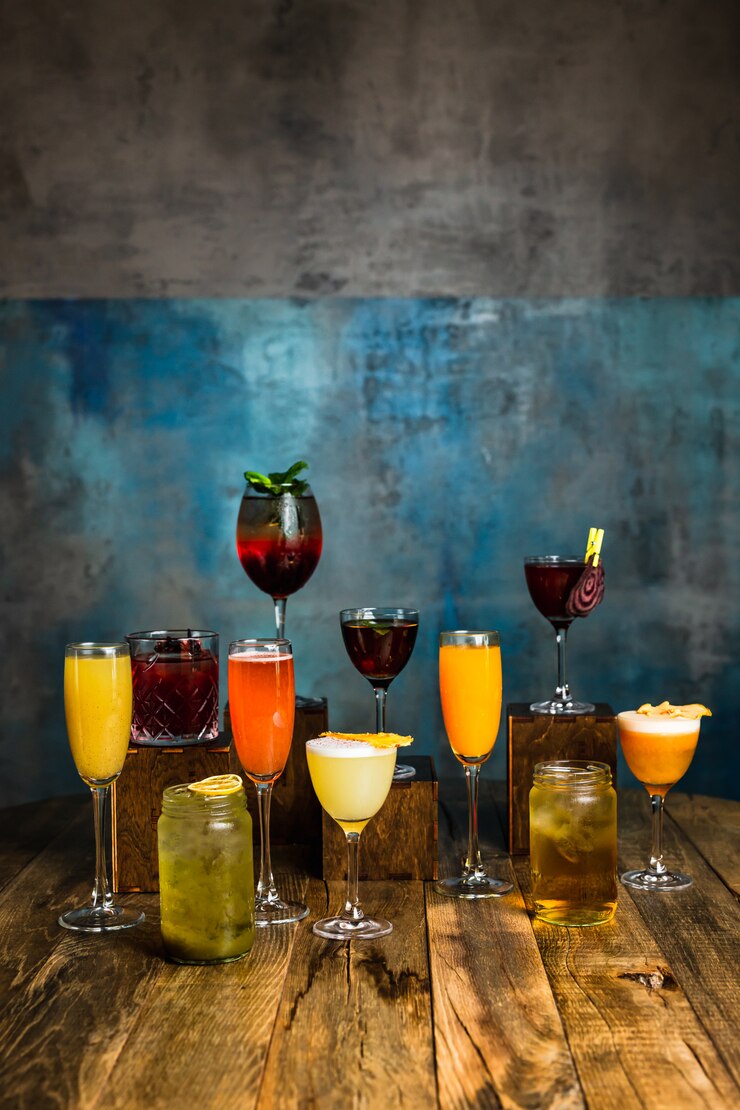 Een grote verscheidenheid aan alcoholische cocktails in verschillende glazen op een houten oppervlak