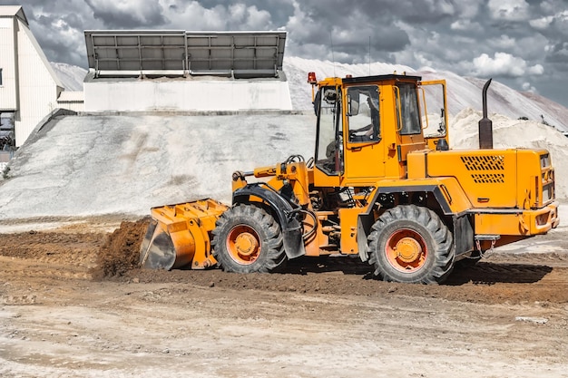 Een grote voorlader giet zand in een stapel op een bouwplaats transport van bulkmaterialen bouwmachines bulkladingtransport opgraving