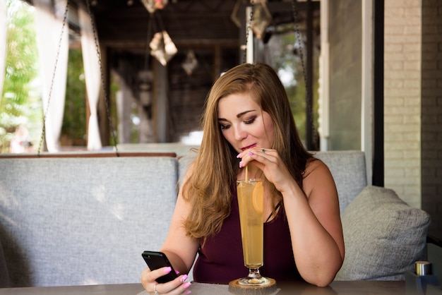 Een grote vrouw die van het leven geniet, limonade drinkt.