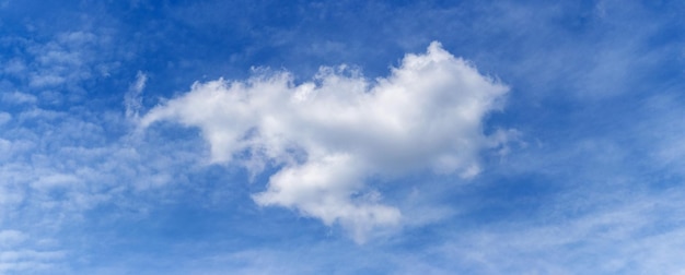 Een grote witte pluizige wolk van een vreemde vorm in de blauwe lucht