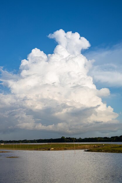 Een grote wolk in de lucht hangt boven een rivier.