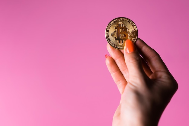 Een hand die een gouden munt vasthoudt met het woord euro erop