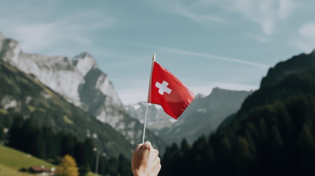 Een hand die een Zwitserse vlag vasthoudt voor een berg