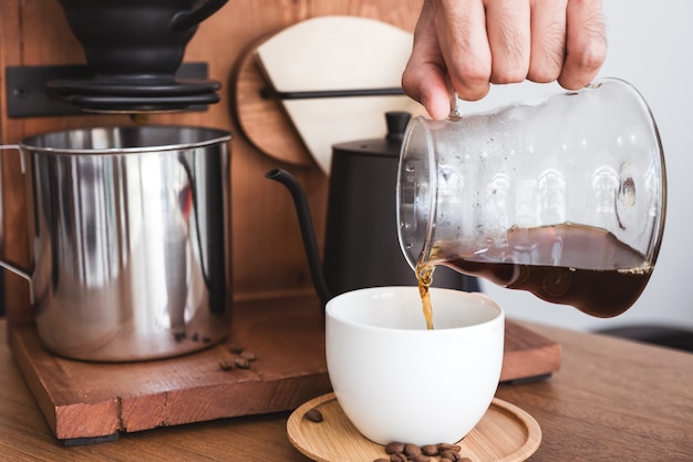 Een hand die infuuskoffie in een mok giet