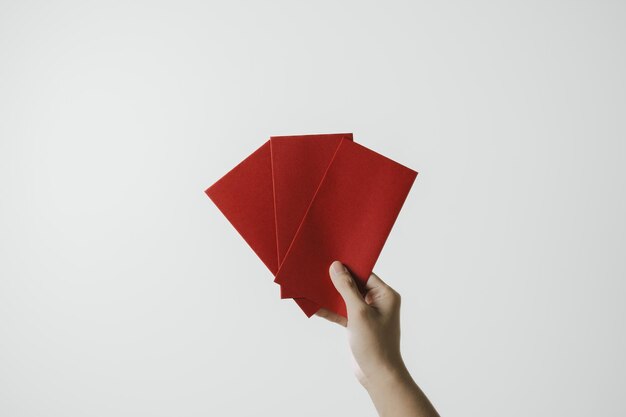 Foto een hand houdt angpao of rood geldig geschenk op witte achtergrond chinees nieuwjaar concept gong xi fa cai