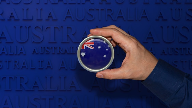 Een hand met een badge met de nationale vlag van Australië op een donkerblauwe achtergrond