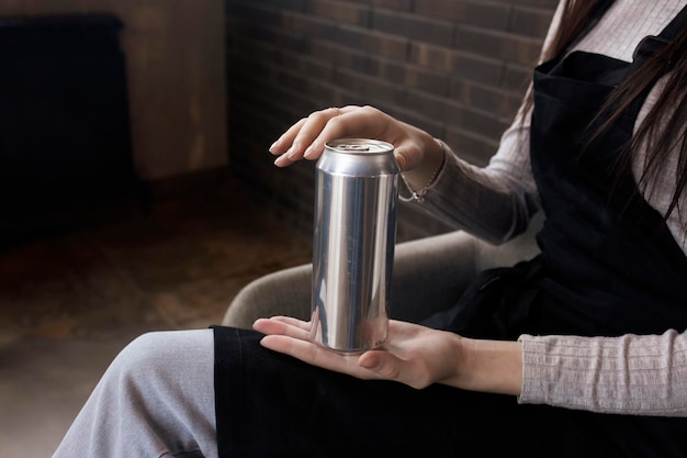 Een hand met een blanco aluminium blikje sjabloonmodel met kopieerruimte