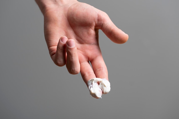 Een hand met witte natuurlijke crème op het concept van de vingers huidverzorging