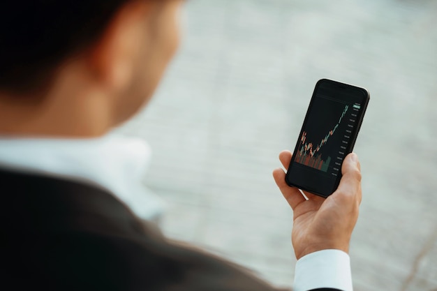 Een handelaar handelt op de beurs in zijn telefoon