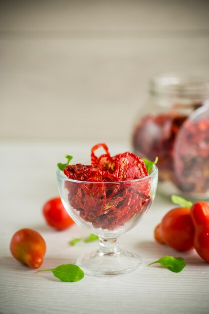 Een handvol gedroogde tomaten en verse tomaten op een lichttafel