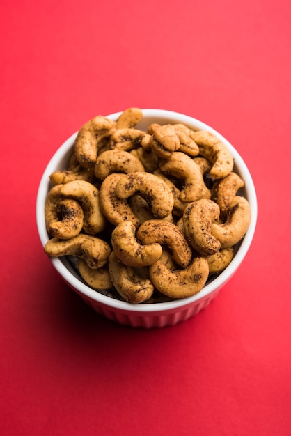 Een handvol geroosterde gekruide cashewnoten of masala kaju geserveerd in een kom, selectieve focus