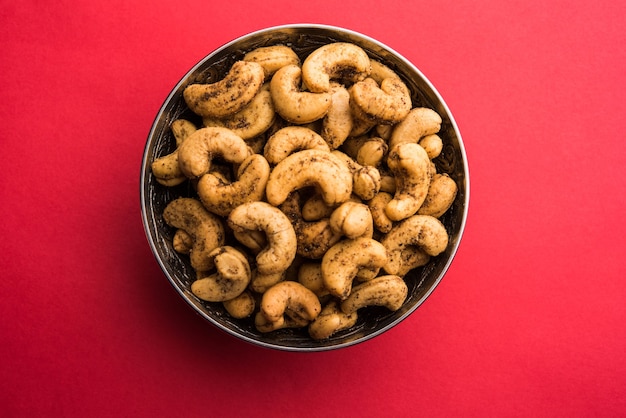 Een handvol geroosterde gekruide cashewnoten of masala kaju geserveerd in een kom, selectieve focus