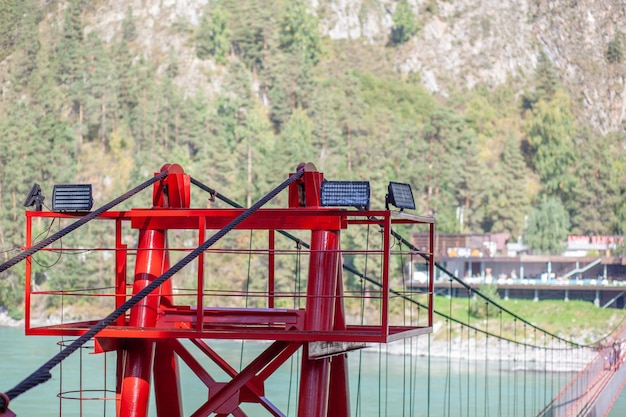 Een hangbrug over een brede rivier in de bergen. Veilige oversteek van de brug van de ene oever naar de andere.