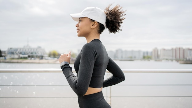 Een hardlopervrouw houdt zich bezig met fitness in comfortabele sportkleding, een slim horloge en een tracker op haar hand