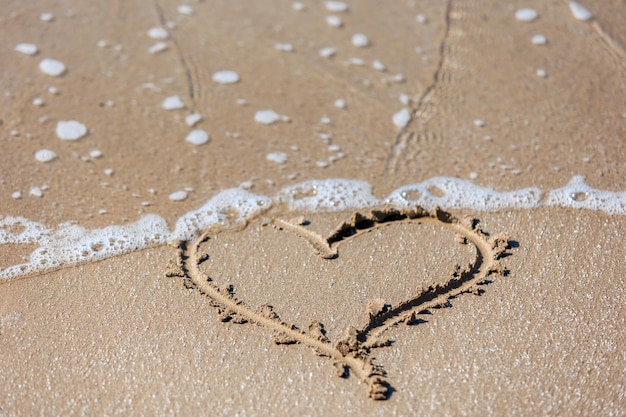 Een hart geschilderd op het zand op Valentijnsdag aan de kust en alle geliefden