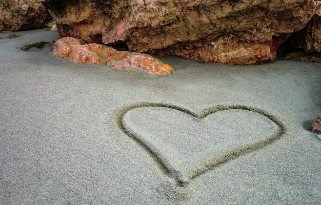 Een hart getekend op het zand van het ongerepte strand: een gebaar van zoete en poëtische liefde voor degenen die echt liefhebben