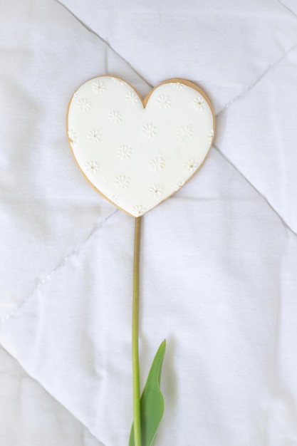 Een hartvormig koekje met een bloem erop