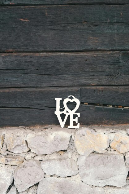 Foto een hartvormige metalen letter i en het woord liefde op een stenen muur