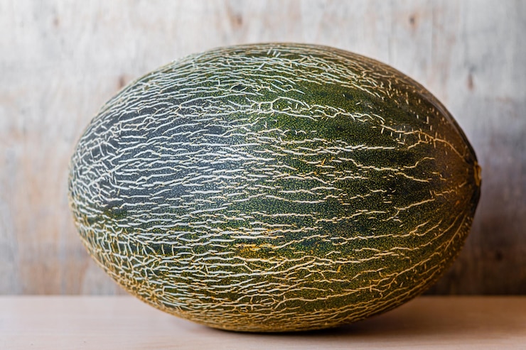 Foto een heel stuk meloen op een houten achtergrond
