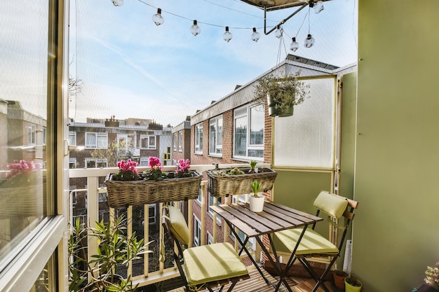 Een heerlijk klein en gezellig balkon met een houten tafel en stoel