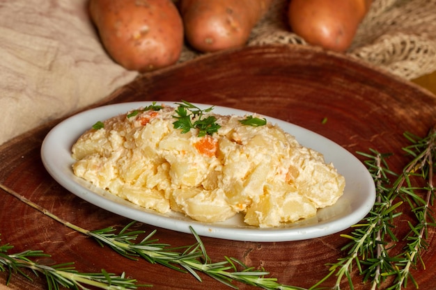 Een heerlijke huisgemaakte romige aardappelsalade in een rustieke setting met verse ingrediënten i