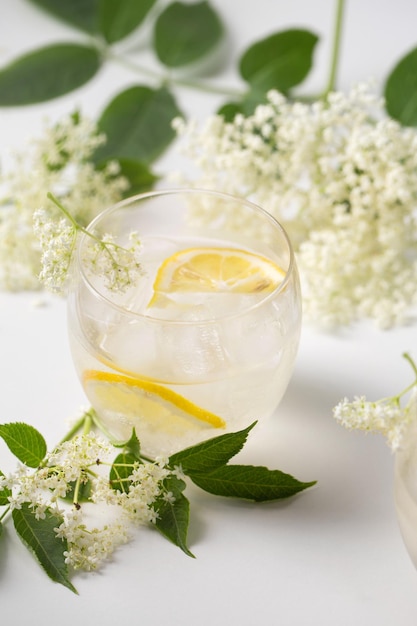 Een heerlijke koude zomerdrank gemaakt van oesterbloemen en citroen met ijs op een lichte achtergrond