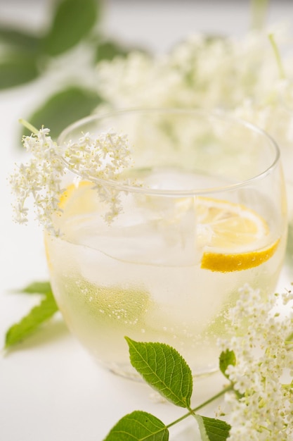 Een heerlijke koude zomerdrank gemaakt van oesterbloemen en citroen met ijs op een lichte achtergrond