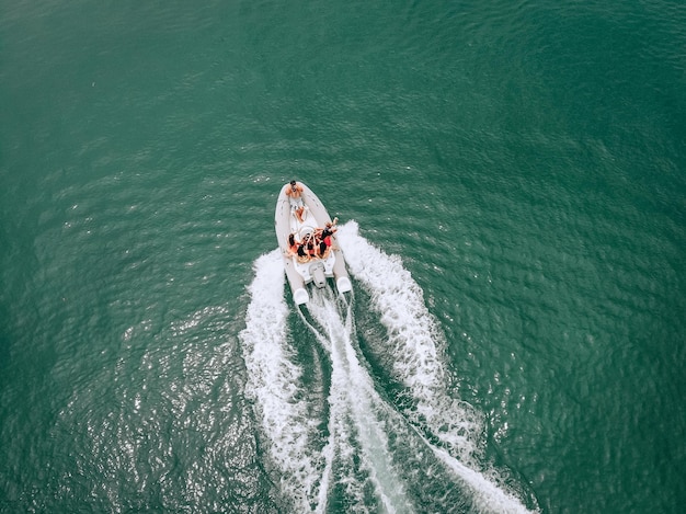 Een heldere luchtfoto op een zonnige hete zomerdag. Prachtige jonge meisjes in zwemkleding poseren voor een zittende man die een camera vasthoudt voor een foto. Zomer groepsfoto. Vakantie fotosessie concept.