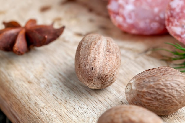 Een hele nootmuskaat op een houten bord een hele nootmuskaat die wordt gebruikt bij het koken bij het bereiden van vleesgerechten